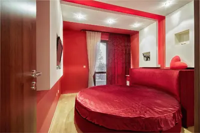 a red bedroom with a red bed and a window at The Love Nest - 1BD Apartment in Sunny Beach by Flat Mаnаger in Sunny Beach