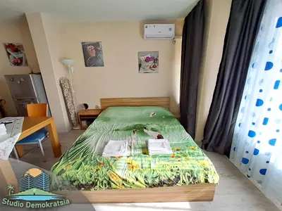 a bedroom with a bed with a green comforter at Studio Demokratsia in Burgas City