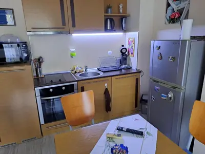 a kitchen with a stainless steel refrigerator and a table at Studio Demokratsia in Burgas City