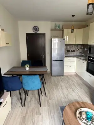 a kitchen with a table and chairs and a refrigerator at Apartament CASCADAS FAMILY in Sunny Beach