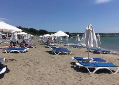 a group of chairs and umbrellas on a beach at Sea angel in Burgas City