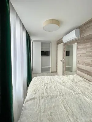 a bedroom with a large bed and a window at SOS CoMFORT 2 LAZUR in Burgas City