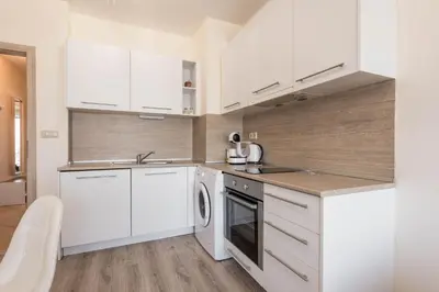 a kitchen with white cabinets and a dishwasher at Casa de la playa in Varna City