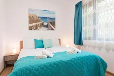 a bedroom with a bed with a blue blanket and a window at Peaceful Central Place - Vazov street in Varna City