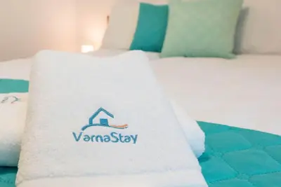 a white towel sitting on top of a bed at Peaceful Central Place - Vazov street in Varna City