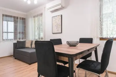 a dining room with a table and chairs and a couch at Peaceful Central Place - Vazov street in Varna City
