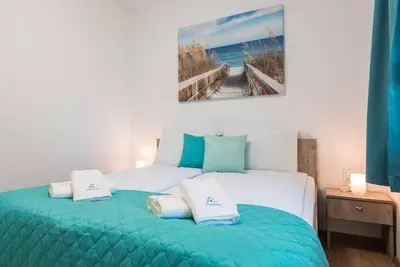 a bedroom with a large bed with blue and white pillows at Peaceful Central Place - Vazov street in Varna City