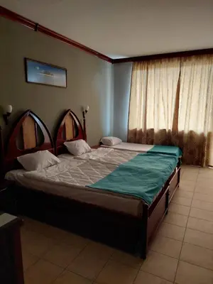 a bedroom with a large bed in front of a window at Hotel Niko's in Pomorie