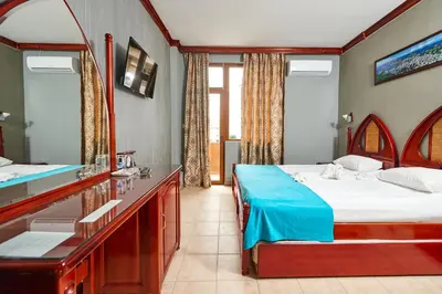 a bedroom with a bed and a sink and a mirror at Hotel Niko's in Pomorie