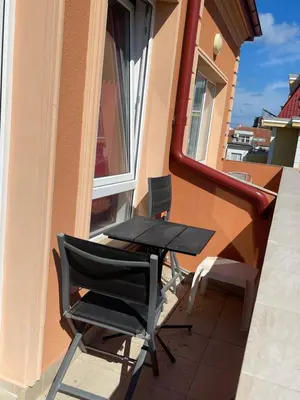 a table and chairs on the balcony of a building at A Tiny Flat in Sunny Beach