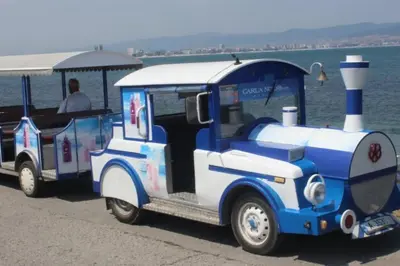 a small blue and white train car parked next to the water at Apartment for rent in Sunny Beach/ Nessebar in Nesebar