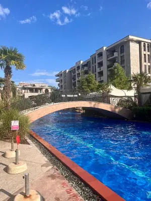 a large swimming pool with a bridge in front of a building at Deluxe Appartements in Cascadas Family Resort Sunny Beach in Sunny Beach