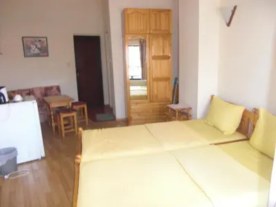 a room with a bed and a kitchen with a table at Guest House Antoaneta in Nesebar