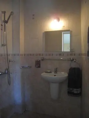a bathroom with a sink and a shower with a mirror at Guest House Antoaneta in Nesebar