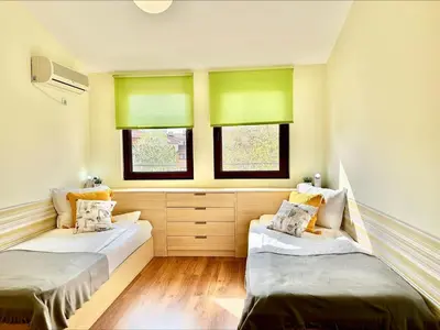 two beds in a room with green windows at Sea View Apartments - Aheloy in Ravda