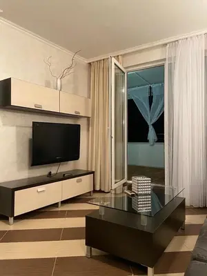 a living room with a tv and a glass table at SEAVIEW Heaven Sunny Beach in Sunny Beach