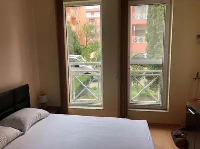 a bedroom with a bed and a large window at Ground Floor, Studio Apartment at Sunny Day 6 in Tŭnkovo