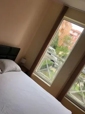 a bedroom with a bed and a large window at Ground Floor, Studio Apartment at Sunny Day 6 in Tŭnkovo