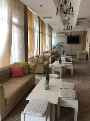 a living room with couches and tables and a television at Spacious, 1 Bed Apt, Dawn Park in Sunny Beach