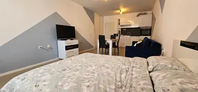 a bedroom with a bed and a tv and a kitchen at Studio Nina in Primorsko