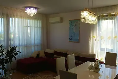 a living room with a couch and a table at Прекрасный апартамент с видом на море и бассейном in Byala