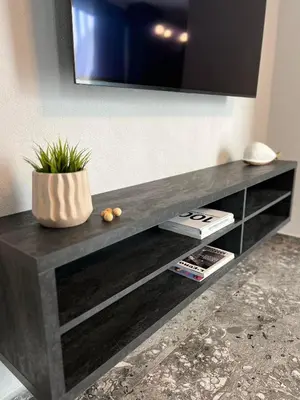 a black entertainment center with a television on a wall at Villas Park Lozenets in Lozenets
