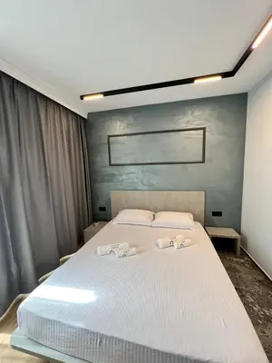 a bedroom with a large white bed with towels on it at Villas Park Lozenets in Lozenets