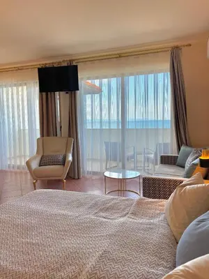 a bedroom with a bed and a living room at SH Holidays & Health Beach-Apartments in Sozopol