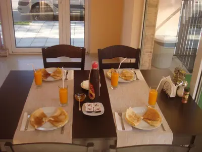 a table with plates of food and orange juice at Ivatea Family Hotel in Ravda