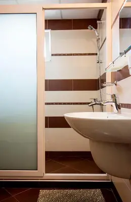 a bathroom with a sink and a glass shower door at Ivatea Family Hotel in Ravda