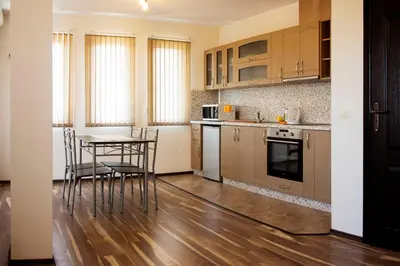 a kitchen with a table and chairs in a room at Ivatea Family Hotel in Ravda