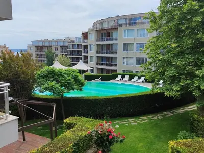 a swimming pool in front of a building at Апартамент Sunny home in Chernomorets