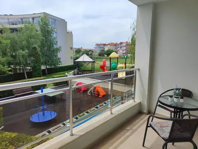 a balcony with a view of a playground at Апартамент Sunny home in Chernomorets