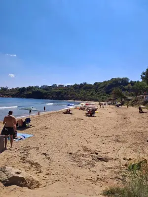 a group of people walking on a beach at Апартамент Sunny home in Chernomorets