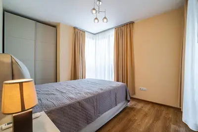 a hotel room with a bed and a window at Brand New Downtown Apartment in Varna City