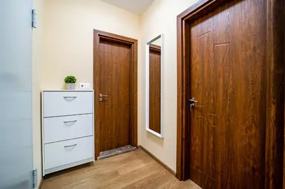 a hallway with two wooden doors and a dresser at Brand New Downtown Apartment in Varna City