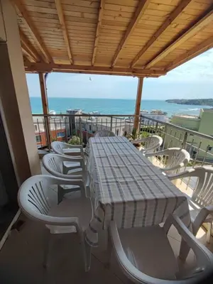 a table and chairs on a balcony with the ocean at The View Apartment in Sozopol