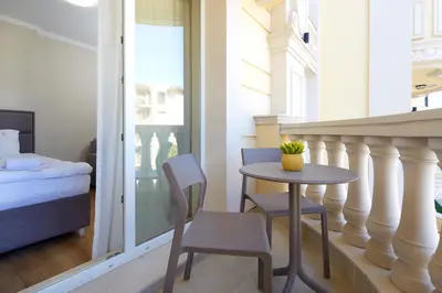 a small table and chairs in a room with a bed at Bellicity Apart Complex in Ravda