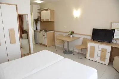 a bedroom with a bed and a kitchen with a table at Hotel Paradise Garden in Chernomorets