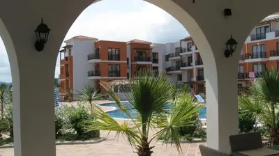 a view from an archway of a pool and buildings at Hotel Paradise Garden in Chernomorets