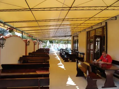 a man sitting at a table in a restaurant at Cantilena Complex in Sunny Beach