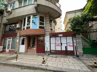 a building with a red door on a street at Център Варна апартамент с паркинг за нормална до средно голяма кола in Varna City