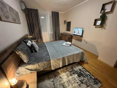 a bedroom with a bed and a television in it at Център Варна апартамент с паркинг за нормална до средно голяма кола in Varna City
