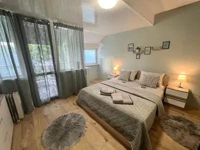 a bedroom with a large bed and a large window at Център Варна апартамент с паркинг за нормална до средно голяма кола in Varna City