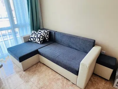 a blue and white couch in a room with a window at Elit 4 Apartments in Sunny Beach