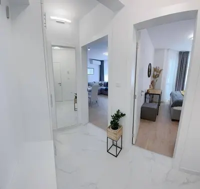 a white living room with a mirror and a couch at Nova City Apartments in Varna City