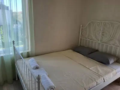 a bedroom with a white bed with a window at Комплекс Конти in Ravda