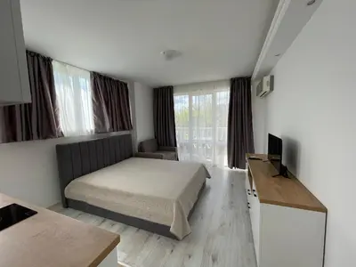 a small bedroom with a bed and a television at Студио Симона 5 първа линия море in Lozenets