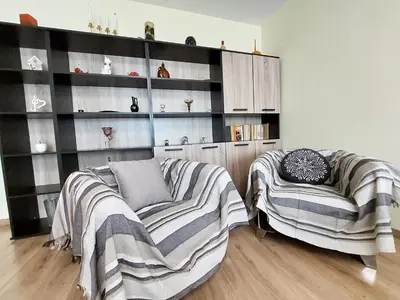 a living room with two chairs and a book shelf at Апартамент за гости , жк. Зорница, бл.36 in Burgas City