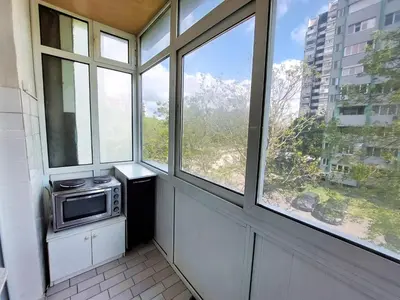 a kitchen with a microwave in a room with windows at Апартамент за гости , жк. Зорница, бл.36 in Burgas City